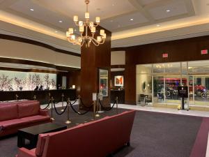 a lobby with a red couch and a chandelier at Lucky Gem Penthouse & Luxury Suites at Signature Resort, Balcony Strip View 3505 in Las Vegas