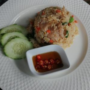 a plate of food with rice and cucumbers and a sauce at Sleep Easy Krabi Guest House in Krabi