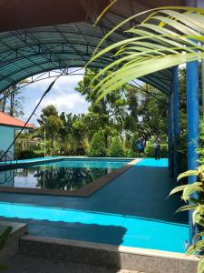 a pool at the resort with people walking around it at Sripiamsuk Resort Bangkok in Pathum Thani