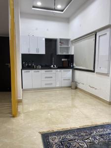 a kitchen with white cabinets and a tile floor at Amritsar Homes - A perfect home away from home in Amritsar