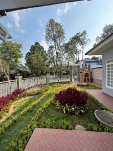 Eton Asia Kota Bunga Villas في بونشاك: حديقة في منزل مع سياج أبيض