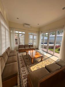 Eton Asia Kota Bunga Villas في بونشاك: غرفة معيشة مع أريكة وطاولة قهوة