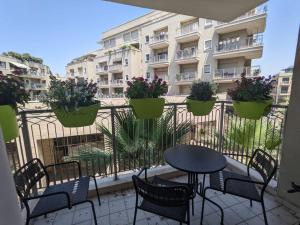 a balcony with a table and chairs and a building at Jaffa's Hideaway - Lux 2BR w/balcony and parking! in Tel Aviv