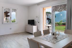 a dining room with a table and chairs and a television at Appartamenti Zerboni in Lenno