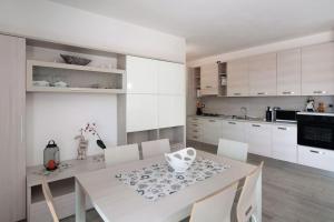 レンノにあるAppartamenti Zerboniのキッチン(白いテーブル、白いキャビネット付)