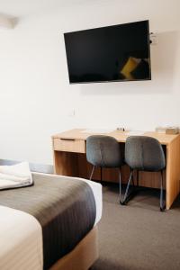 a room with a desk with two chairs and a television at Ceduna Foreshore Hotel Motel in Ceduna