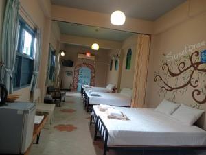 a row of four beds in a room at Chanchaolao Beach Resort in Chao Lao Beach