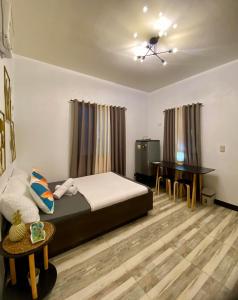 a bedroom with a bed and a desk in it at Shanti's Inn in General Luna +7 photos