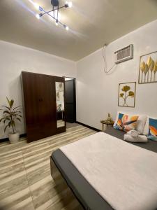 a bedroom with a large bed and a ceiling fan at Shanti's Inn in General Luna