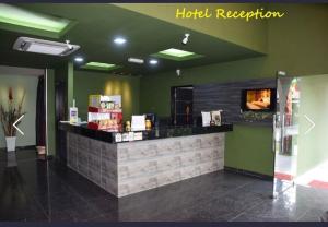 a hotel reception counter in a room with green walls at I Garden Hotel in Ipoh