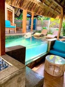 a pool in a resort with chairs and a table at Villa Amuntai with Pool & Jacuzzi in Dinalupihan