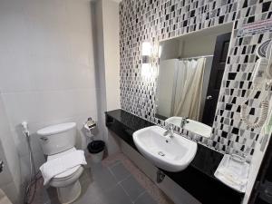 a bathroom with a white toilet and a sink at Chiangkhong Teak Garden Riverfront Onsen Hotel- SHA Extra Plus in Chiang Khong