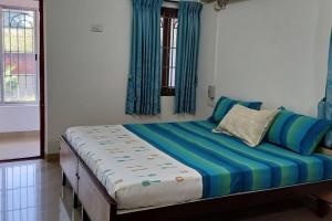 a bedroom with a bed with blue and white at SHI's Alayam 3BHk Villa in Avinashi road, near Railway station in Pīlamedu