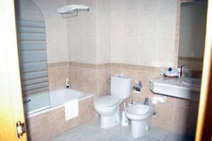 a bathroom with a toilet and a tub and a sink at La Luna Blanca in Torremolinos