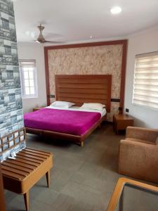 een slaapkamer met een groot bed en een paarse deken bij La Gabriell beach inn in Calangute