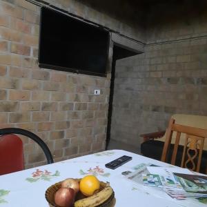 a table with a television and a basket of fruit on it at Casa 2 dormitorios in Oberá