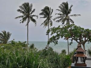 a view of the ocean from a resort with palm trees at The Wynn Kohjum in Ko Jum