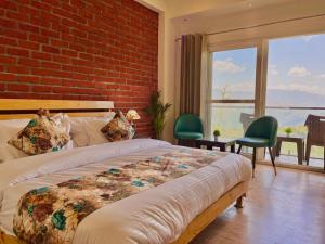 a bedroom with a bed and a brick wall at Hotel Pinerock & Cafe, Mussoorie - Mountain View Luxury Rooms with open Rooftop Cafe in Mussoorie