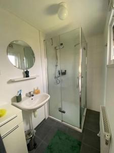 y baño con ducha acristalada y lavamanos. en Chalet with 2 bedrooms for 4 people for rent in Hoorn Netherlands, en Hoorn