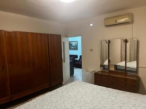 a bedroom with a bed and a dresser and a mirror at Madaba Hills Apt in Madaba