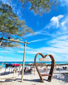 a swing at the beach with a heart sign at SUITEs E FLATs MONTE ALTO ARRAIAL DO CABO in Arraial do Cabo