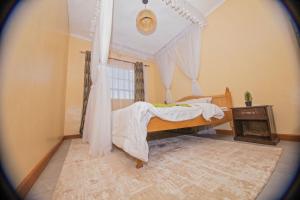 a bedroom with a bed with a canopy at Ebony Mara - Green House in Narok