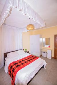 una camera con un letto con una coperta rossa e nera di Ebony Mara a Narok