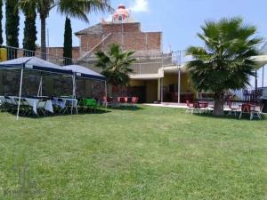une cour avec des tables et des parasols devant un bâtiment dans l'établissement Terraza Lotelazo, à Guadalajara