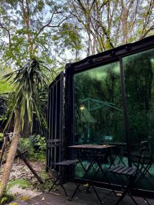 a black shelter with a picnic table in a forest at Time Capsule Retreat, Sungai Lembing in Sungai Lembing