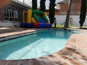 une piscine avec un toboggan et une aire de jeux dans l'établissement Terraza Lotelazo, à Guadalajara