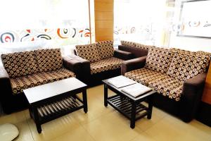 een wachtkamer met twee banken en een tafel bij sitthi residency in Kumbakonam