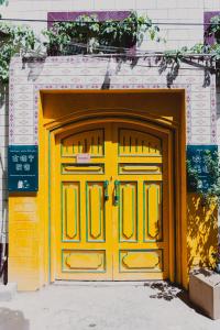 uma porta amarela em frente a um edifício em Good Morning Homestay Inn em Kashgar