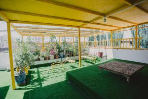 eine Terrasse mit einem Tisch und einigen Topfpflanzen in der Unterkunft Good Morning Homestay Inn in Kashgar