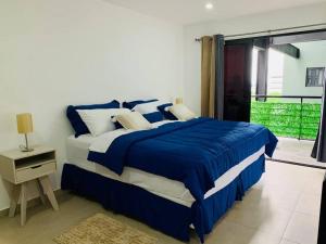 a bedroom with a blue and white bed and a window at Second Home in San Salvador