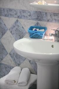Baño con lavabo y cesta en Paros Inn, en Logaras