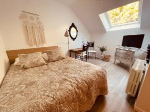 um quarto com uma cama, uma secretária e uma televisão em Les Suites du 119 em Vannes