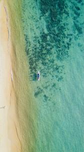 an overhead view of a boat in the water on a beach at KAMAKU Bungalows in Koh Rong Sanloem