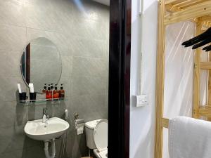 W łazience znajduje się umywalka, toaleta i lustro. w obiekcie Hanoi AVANA HOMESTAY LONG BIEN w mieście Hanoi