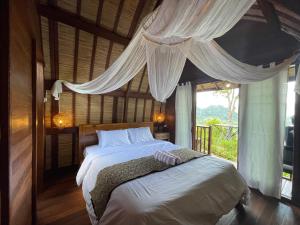 a bedroom with a bed with white sheets and a window at Taman Asta Gangga by ecommerceloka in Silebeng