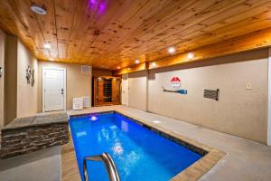 a pool in a room with a wooden ceiling at Heavenly Heights by Ghosal Luxury Lodging in Sevierville