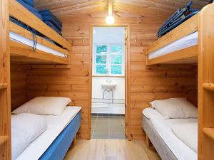 2 Etagenbetten in einem Holzzimmer mit Fenster in der Unterkunft Holiday home Holbæk III in Holbæk
