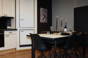a dining room with a table with chairs and wine glasses at Le petit Chermont in Saint-Hubert