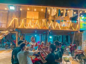 a group of people sitting at a table with drinks at Tuệ Nhi Homestay Ngườm Ngao Bản Giốc in Cao Bằng