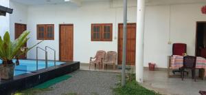 a pool in a house with chairs and a table at Italiano Safari House in Udawalawe