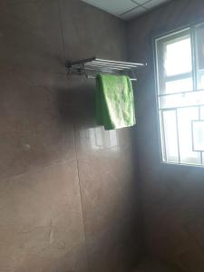 a bathroom with a shower with a green towel at Swayamkrushi 3rd Floor in Hyderabad +12 photos