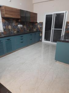 a kitchen with blue cabinets and a tile floor at Swayamkrushi 3rd Floor in Hyderabad