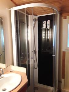 a shower with a glass door in a bathroom at Cap d'Agde chalet vue sur la mer in Agde