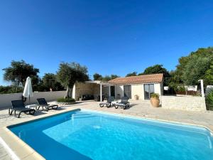 a swimming pool with chairs and a house at VILLA KRISTINA 2BR Villa NR Gaios w Seaview and Pool in Gaios
