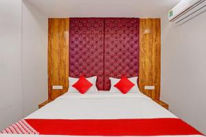 Un dormitorio con una cama grande con almohadas rojas. en HOTEL GK VILLA, en Ahmedabad