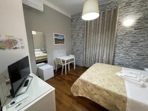 Habitación con cama, TV y dormitorio. en Rooms & Breakfast La Filigrana, en Fabriano